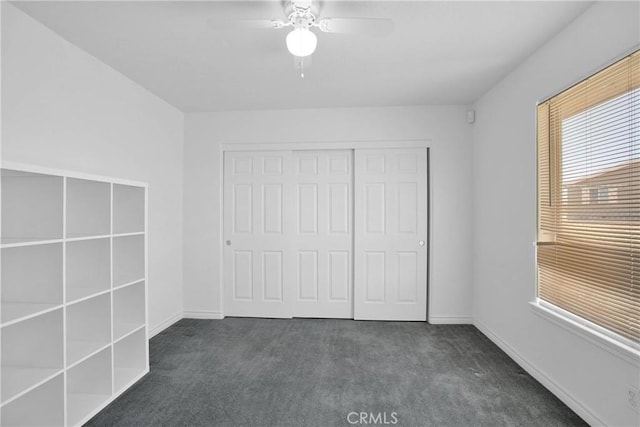 14480 Nevada Rd, Phelan, CA 92371 - unfurnished bedroom with dark carpet, a closet, and ceiling fan