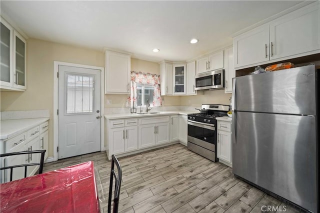 6838 Severn Dr, Paramount, CA 90723 - kitchen with stainless steel appliances, light countertops, light wood-style floors, white cabinetry, and recessed lighting