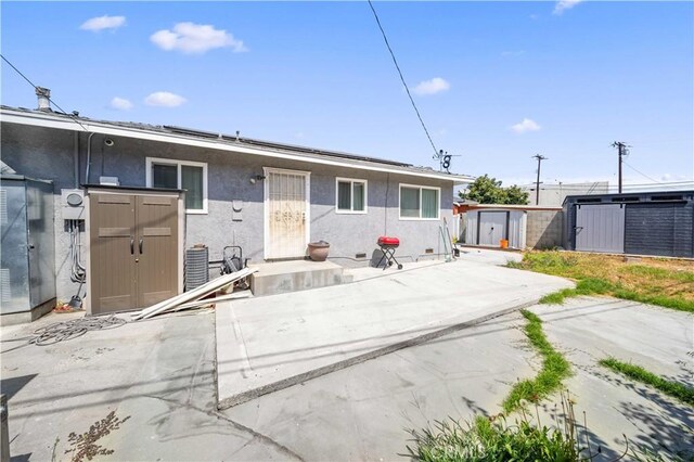 6838 Severn Dr, Paramount, CA 90723 - back of property with a storage shed, stucco siding, and solar panels
