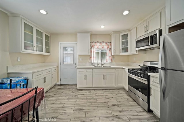 6838 Severn Dr, Paramount, CA 90723 - kitchen with appliances with stainless steel finishes, white cabinets, light countertops, light wood finished floors, and recessed lighting