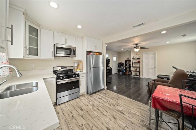 6838 Severn Dr, Paramount, CA 90723 - kitchen featuring stainless steel appliances, recessed lighting, open floor plan, white cabinetry, and light wood-style flooring