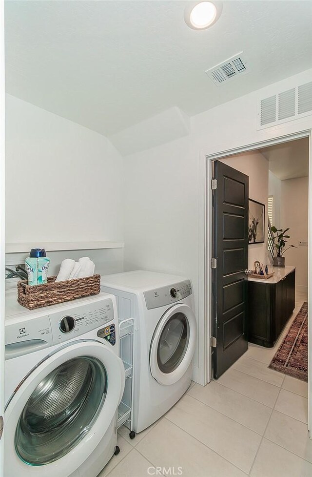 2887 E Tamarind Dr, Fresno, CA 93730 - laundry area featuring washing machine and clothes dryer and light tile patterned flooring