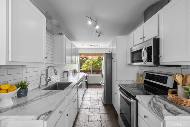 5650 Sumner Way Unit 309, Culver City, CA 90230 - kitchen with stainless steel appliances, white cabinetry, and decorative backsplash