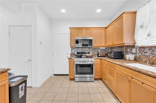 3739 Cherisa St, Perris, CA 92571 - kitchen featuring appliances with stainless steel finishes, backsplash, light tile patterned floors, and light stone countertops