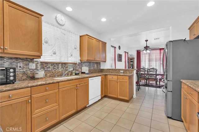 3739 Cherisa St, Perris, CA 92571 - kitchen with freestanding refrigerator, white dishwasher, ceiling fan, light tile patterned floors, and decorative backsplash