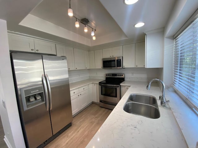1447 Summit Dr, Chula Vista, CA 91910 - kitchen with stainless steel appliances, a raised ceiling, light wood-style floors, white cabinets, and light stone counters