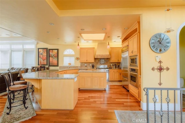 325 Juanita Ave, Oceano, CA 93445 - kitchen featuring custom range hood, stainless steel appliances, light brown cabinets, light wood-style flooring, and healthy amount of natural light