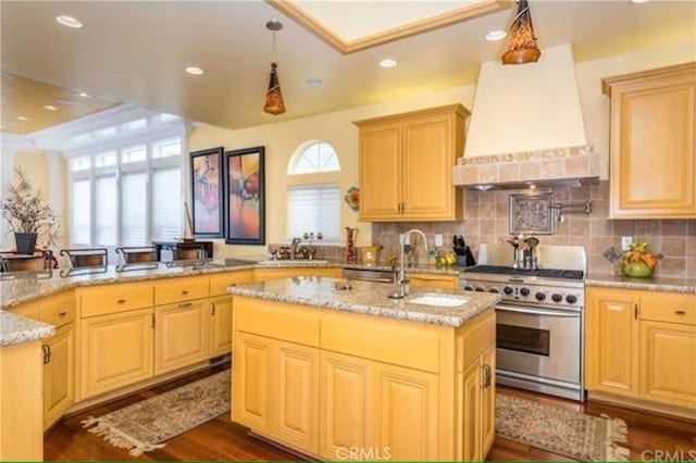 325 Juanita Ave, Oceano, CA 93445 - kitchen featuring stainless steel stove, custom exhaust hood, a kitchen island with sink, light stone countertops, and decorative backsplash