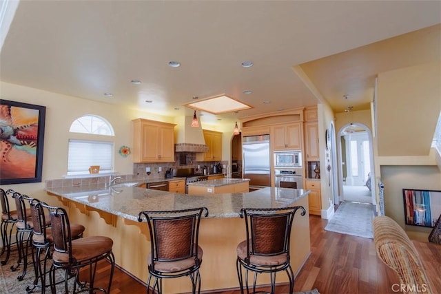 325 Juanita Ave, Oceano, CA 93445 - kitchen with built in appliances, light brown cabinets, wall chimney exhaust hood, decorative backsplash, and dark wood-type flooring
