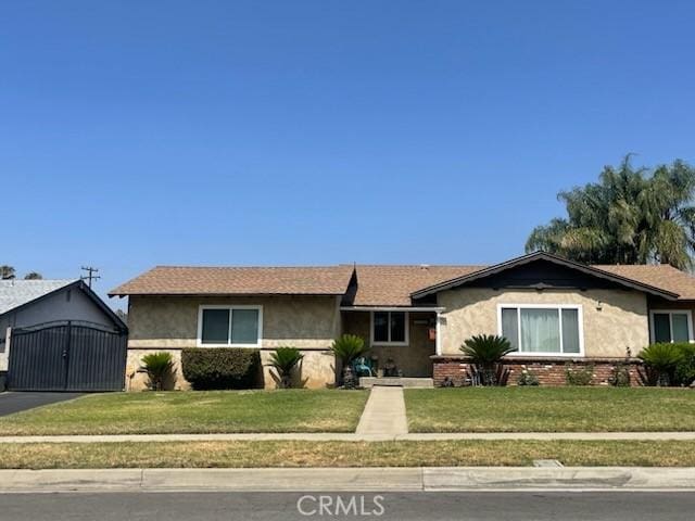 7430 Leucite Ave, Rancho Cucamonga, CA 91730 - ranch-style house featuring stucco siding, a front yard, and an outdoor structure
