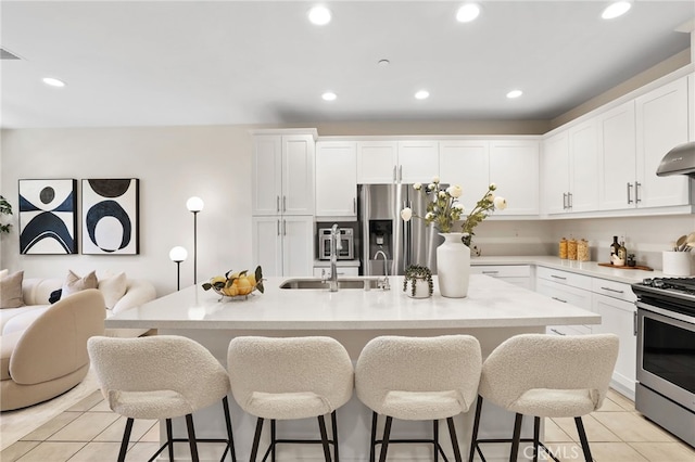 105 High Mdw, Lake Forest, CA 92610 - kitchen featuring appliances with stainless steel finishes, a kitchen bar, recessed lighting, light tile patterned floors, and white cabinets