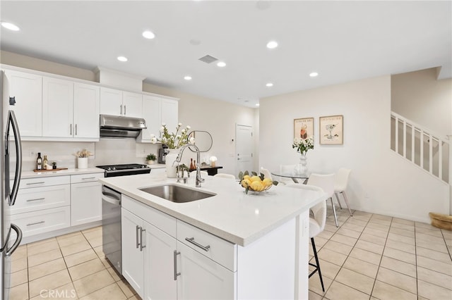 105 High Mdw, Lake Forest, CA 92610 - kitchen featuring under cabinet range hood, appliances with stainless steel finishes, light tile patterned flooring, light countertops, and a breakfast bar