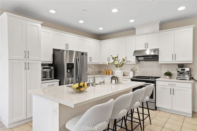 105 High Mdw, Lake Forest, CA 92610 - kitchen with stainless steel appliances, extractor fan, light tile patterned floors, a kitchen bar, and white cabinetry