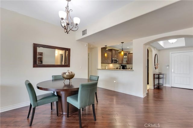 13200 Moorpark St Unit 201, Sherman Oaks, CA 91423 - dining room with arched walkways, a chandelier, and dark wood finished floors