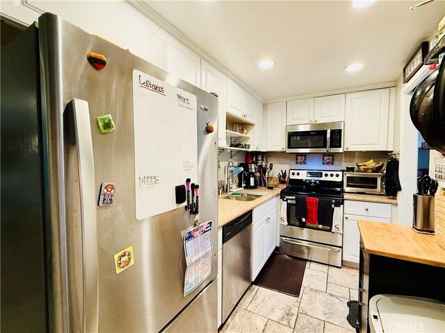 23821 Hillhurst Dr Unit 16, Laguna Niguel, CA 92677 - kitchen featuring appliances with stainless steel finishes, wood counters, white cabinets, recessed lighting, and light stone finish floors