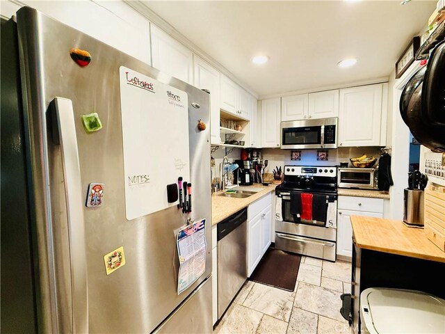 23821 Hillhurst Dr Unit 16, Laguna Niguel, CA 92677 - kitchen featuring appliances with stainless steel finishes, wood counters, white cabinets, stone tile floors, and recessed lighting