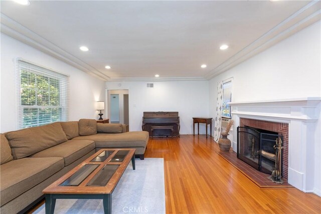 3766 Rose Ave, Long Beach, CA 90807 - living area featuring a brick fireplace, light wood-type flooring, ornamental molding, and recessed lighting