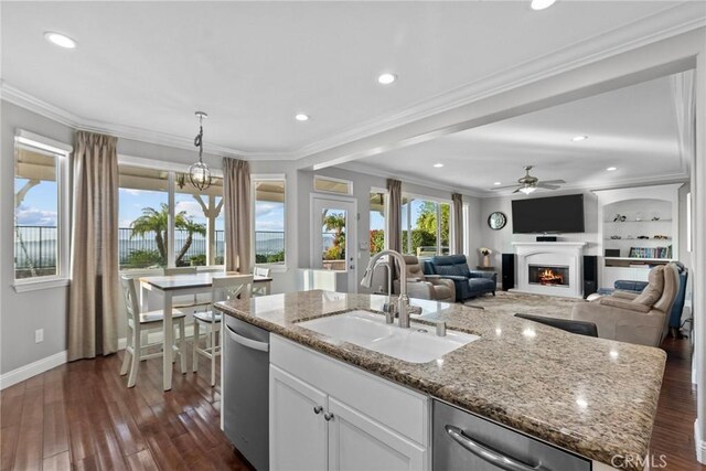 20704 Campania Ln, Porter Ranch, CA 91326 - kitchen with stainless steel dishwasher, dark wood finished floors, ceiling fan, a center island with sink, and a lit fireplace