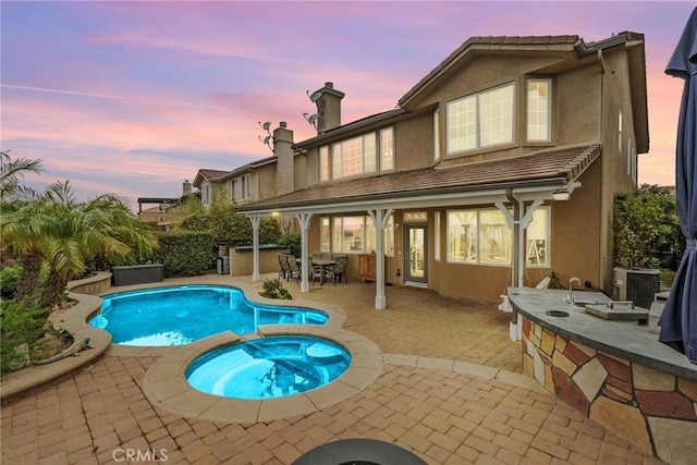 20704 Campania Ln, Porter Ranch, CA 91326 - back of property with a patio, stucco siding, a pool with connected hot tub, and a chimney