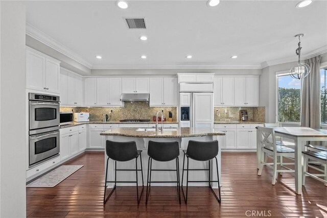 20704 Campania Ln, Porter Ranch, CA 91326 - kitchen featuring stainless steel appliances, under cabinet range hood, crown molding, an island with sink, and a breakfast bar area