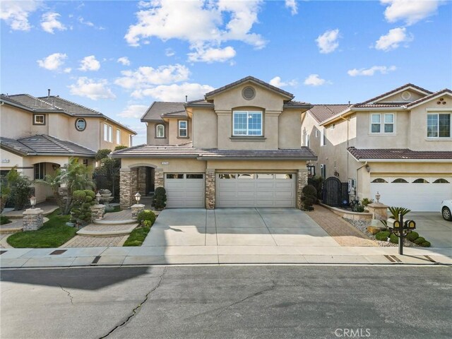 20704 Campania Ln, Porter Ranch, CA 91326 - view of front of home with stucco siding, an attached garage, driveway, and stone siding