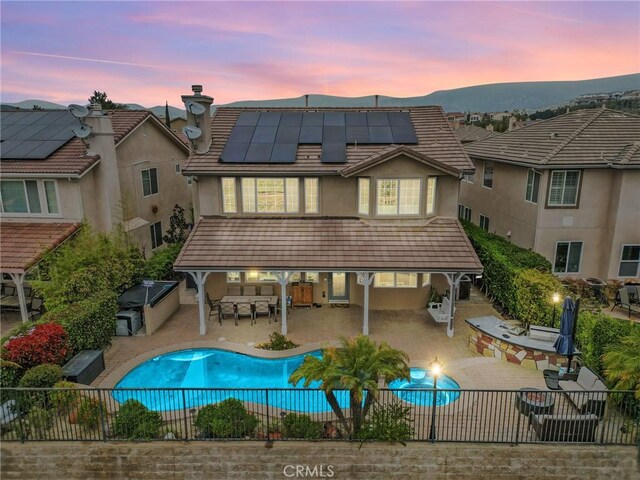 20704 Campania Ln, Porter Ranch, CA 91326 - back of property with a fenced backyard, outdoor dining area, solar panels, stucco siding, and a patio