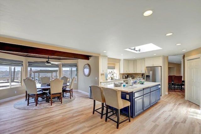 36485 Carney Rd, Valley Center, CA 92082 - kitchen with stainless steel fridge, light wood finished floors, light countertops, a breakfast bar area, and recessed lighting