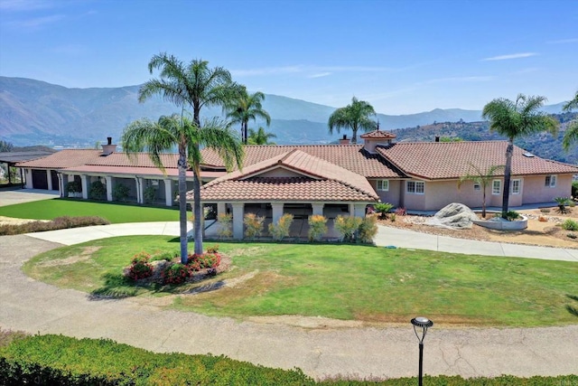 36485 Carney Rd, Valley Center, CA 92082 - view of front facade with a tiled roof, stucco siding, a front yard, a mountain view, and curved driveway