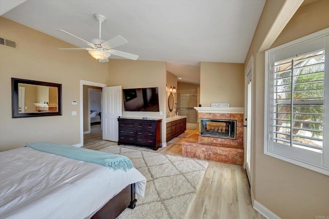 36485 Carney Rd, Valley Center, CA 92082 - bedroom featuring lofted ceiling, multiple windows, light wood-style floors, a fireplace, and ensuite bath