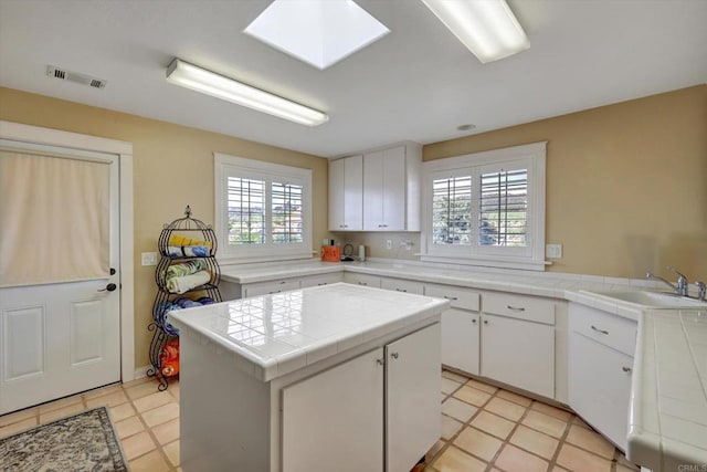 36485 Carney Rd, Valley Center, CA 92082 - kitchen featuring plenty of natural light, a center island, tile counters, and white cabinetry