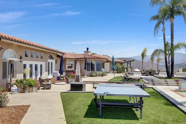 36485 Carney Rd, Valley Center, CA 92082 - back of property with a chimney, a patio, a mountain view, a tiled roof, and stucco siding
