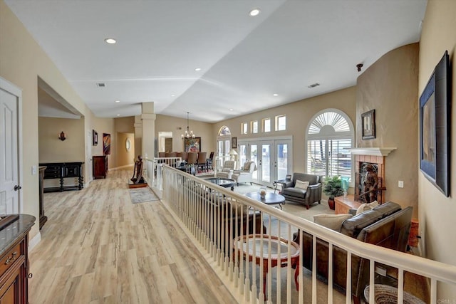 36485 Carney Rd, Valley Center, CA 92082 - living room with decorative columns, light wood-style floors, vaulted ceiling, a fireplace with raised hearth, and recessed lighting