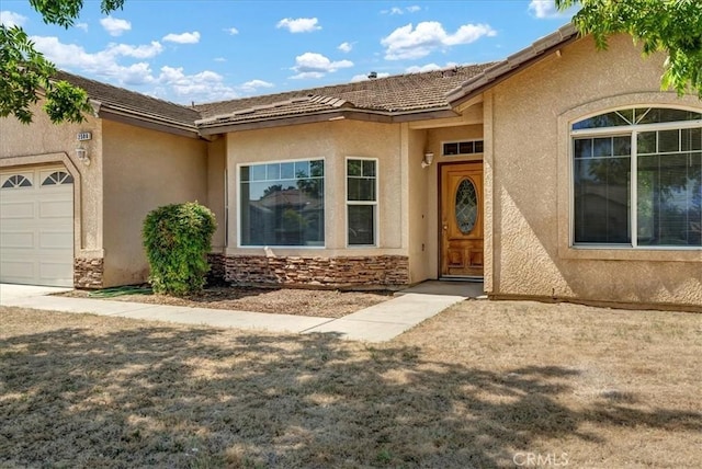 2508 Goldridge St, Selma, CA 93662 - view of exterior entry with stucco siding, a garage, and a tile roof