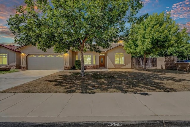 2508 Goldridge St, Selma, CA 93662 - view of property hidden behind natural elements with stucco siding, an attached garage, driveway, and stone siding