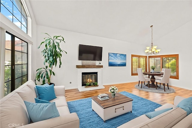 45857 Jeronimo St, Temecula, CA 92592 - living area featuring a chandelier, wood finished floors, high vaulted ceiling, and a brick fireplace