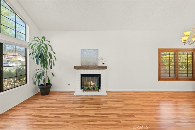 45857 Jeronimo St, Temecula, CA 92592 - unfurnished living room featuring light wood-style floors, a fireplace, a textured ceiling, and a chandelier