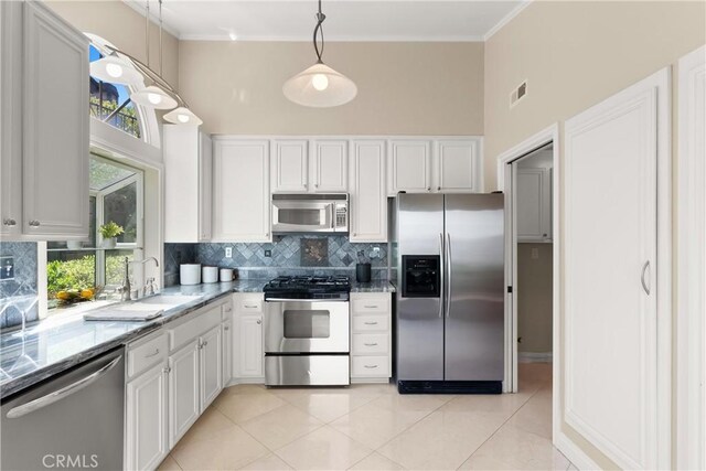 2175 Pacific Ave Unit E4, Costa Mesa, CA 92627 - kitchen featuring stainless steel appliances, a high ceiling, light stone counters, light tile patterned flooring, and tasteful backsplash