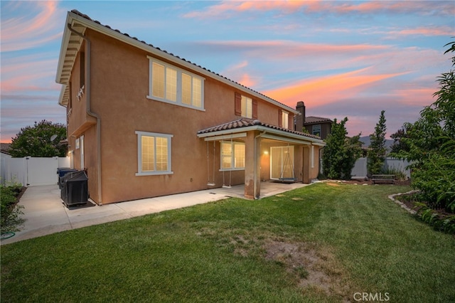 1568 Patterson Ranch Rd, Redlands, CA 92374 - back of property at dusk featuring a patio area, a fenced backyard, stucco siding, and a tile roof