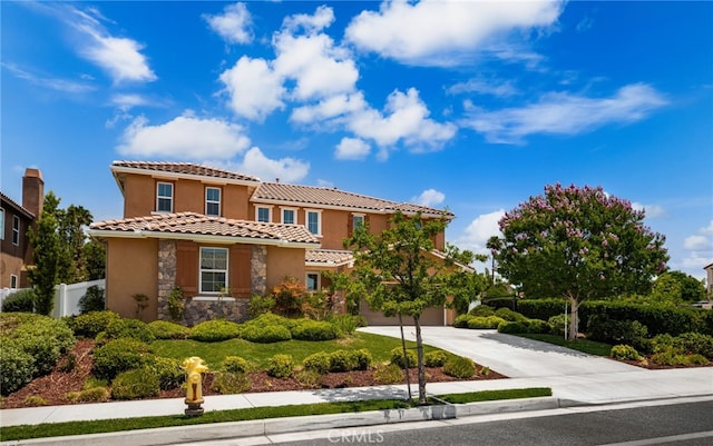 1568 Patterson Ranch Rd, Redlands, CA 92374 - mediterranean / spanish house with driveway, stone siding, a tiled roof, stucco siding, and a garage