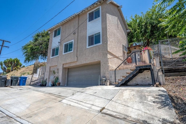 1134 N Rowan Ave, East Los Angeles, CA 90063 - view of side of property with stucco siding, a garage, and driveway