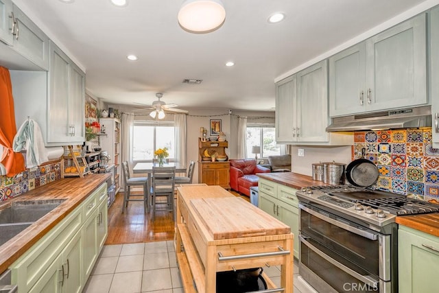 1134 N Rowan Ave, East Los Angeles, CA 90063 - kitchen with butcher block countertops, range with two ovens, green cabinets, under cabinet range hood, and a ceiling fan