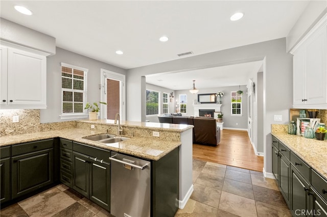 46287 Durango Dr, Temecula, CA 92592 - kitchen featuring stainless steel dishwasher, decorative backsplash, white cabinets, a peninsula, and light stone counters