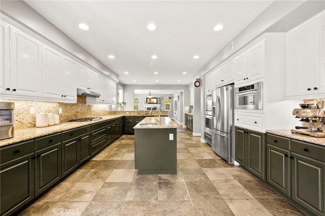 46287 Durango Dr, Temecula, CA 92592 - kitchen featuring stainless steel appliances, white cabinets, a peninsula, light stone counters, and tasteful backsplash