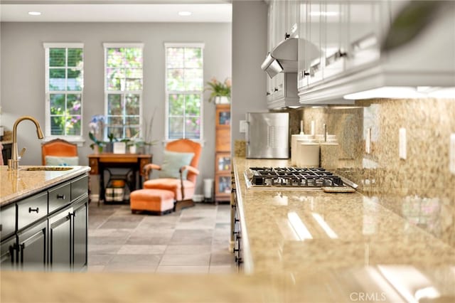 46287 Durango Dr, Temecula, CA 92592 - kitchen with stainless steel gas cooktop, backsplash, healthy amount of natural light, light stone counters, and recessed lighting