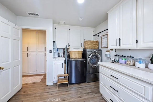 3380 E Date St, Brea, CA 92823 - washroom featuring cabinet space, independent washer and dryer, and light wood-style flooring