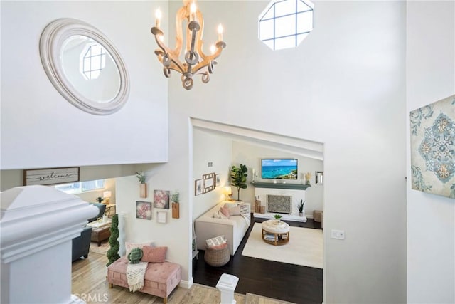 3380 E Date St, Brea, CA 92823 - living area featuring a chandelier, wood finished floors, a brick fireplace, healthy amount of natural light, and a high ceiling