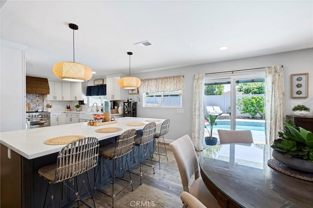 3380 E Date St, Brea, CA 92823 - kitchen featuring high end stainless steel range, light countertops, wood finished floors, custom exhaust hood, and white cabinets