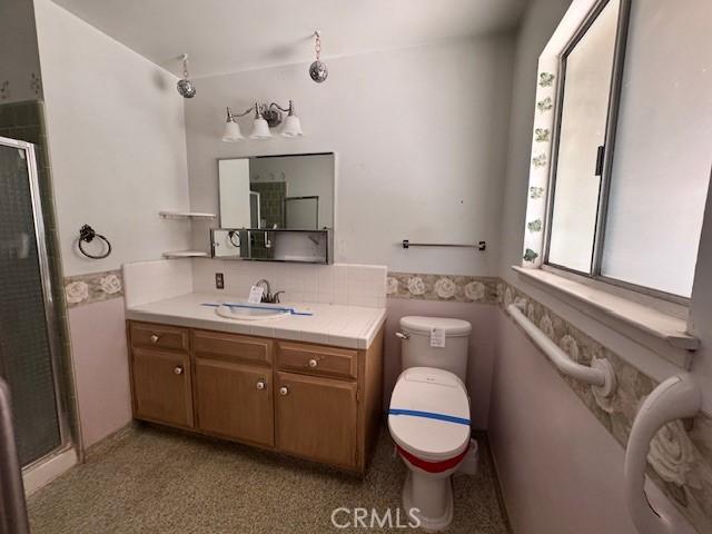 3246 Shamrock Ave, Merced, CA 95340 - bathroom with vanity, a shower stall, and wainscoting