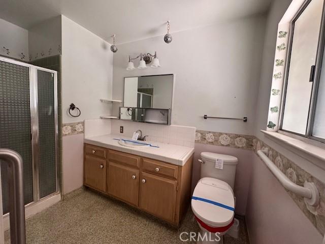 3246 Shamrock Ave, Merced, CA 95340 - bathroom with vanity, a stall shower, tile walls, and a wainscoted wall