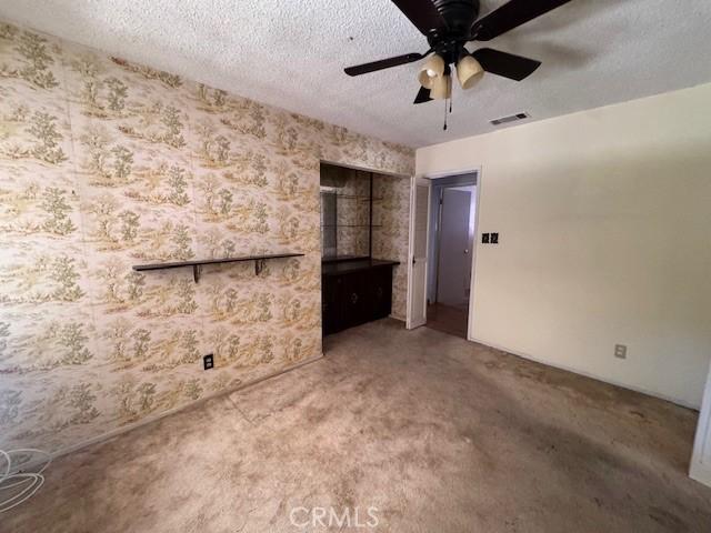 3246 Shamrock Ave, Merced, CA 95340 - unfurnished living room with carpet, a ceiling fan, and a textured ceiling